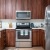 Pet-Friendly Apartments in San Jose CA - LINQ - Kitchen with Wood-Style Flooring, Brown Cabinets, White Quartz Countertops, and Stainless Steel Appliances